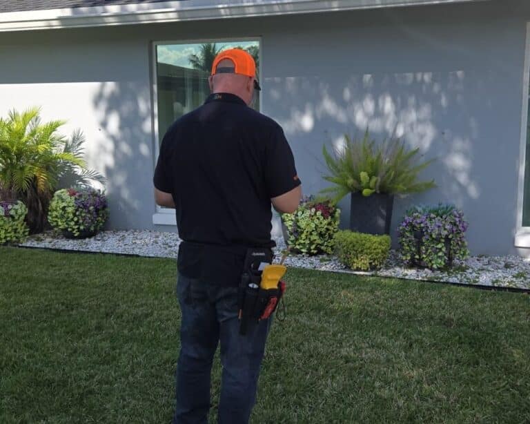 Steve from Absolute Property Inspections in front of house landscape